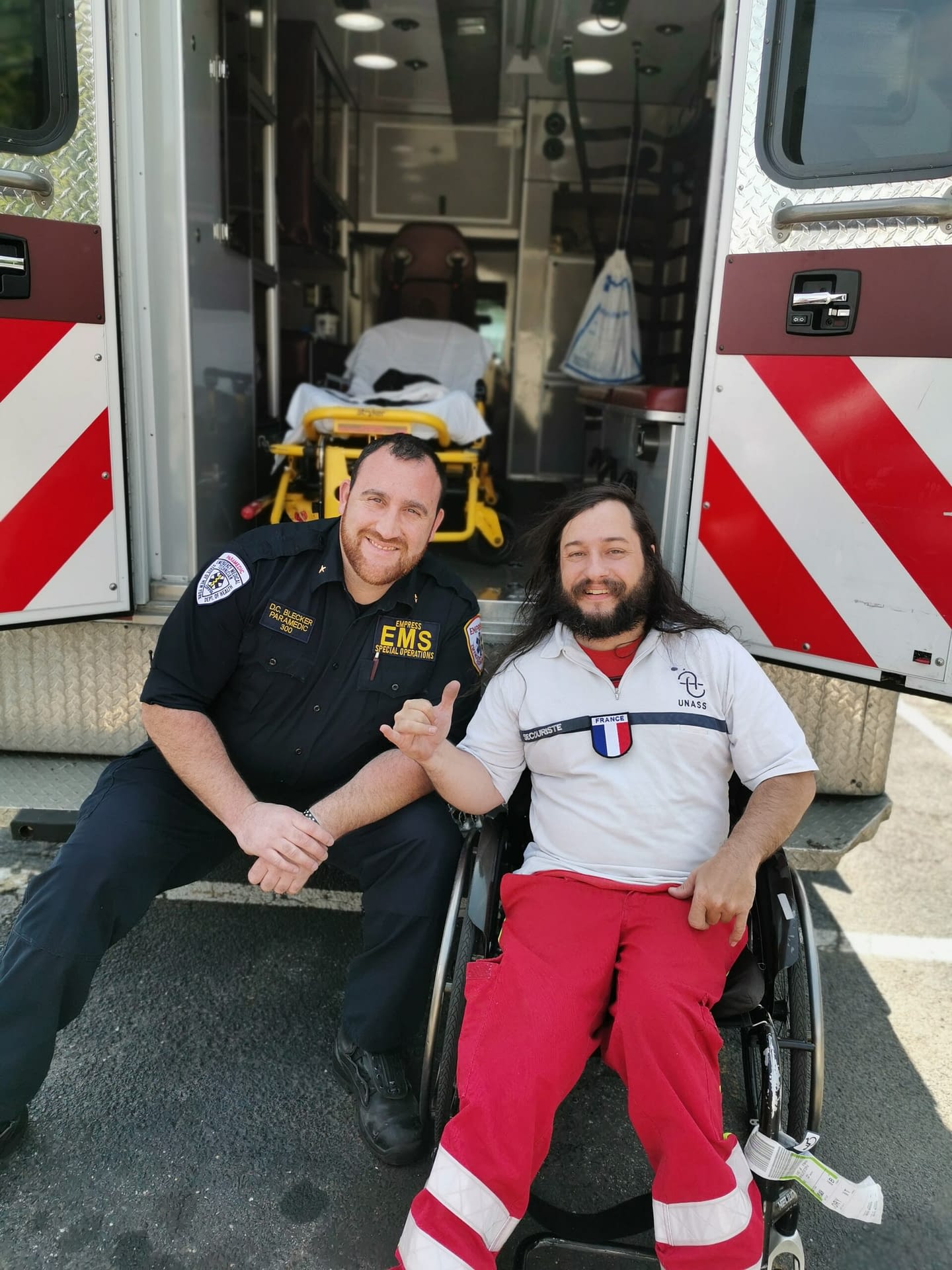 Stéphane Bonvallet avec un professionnel des secours devant une ambulance
